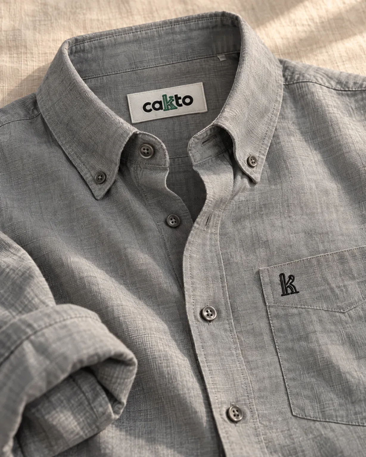 Detalle del cuello, la tela y la etiqueta Cakto de la camisa manga larga gris