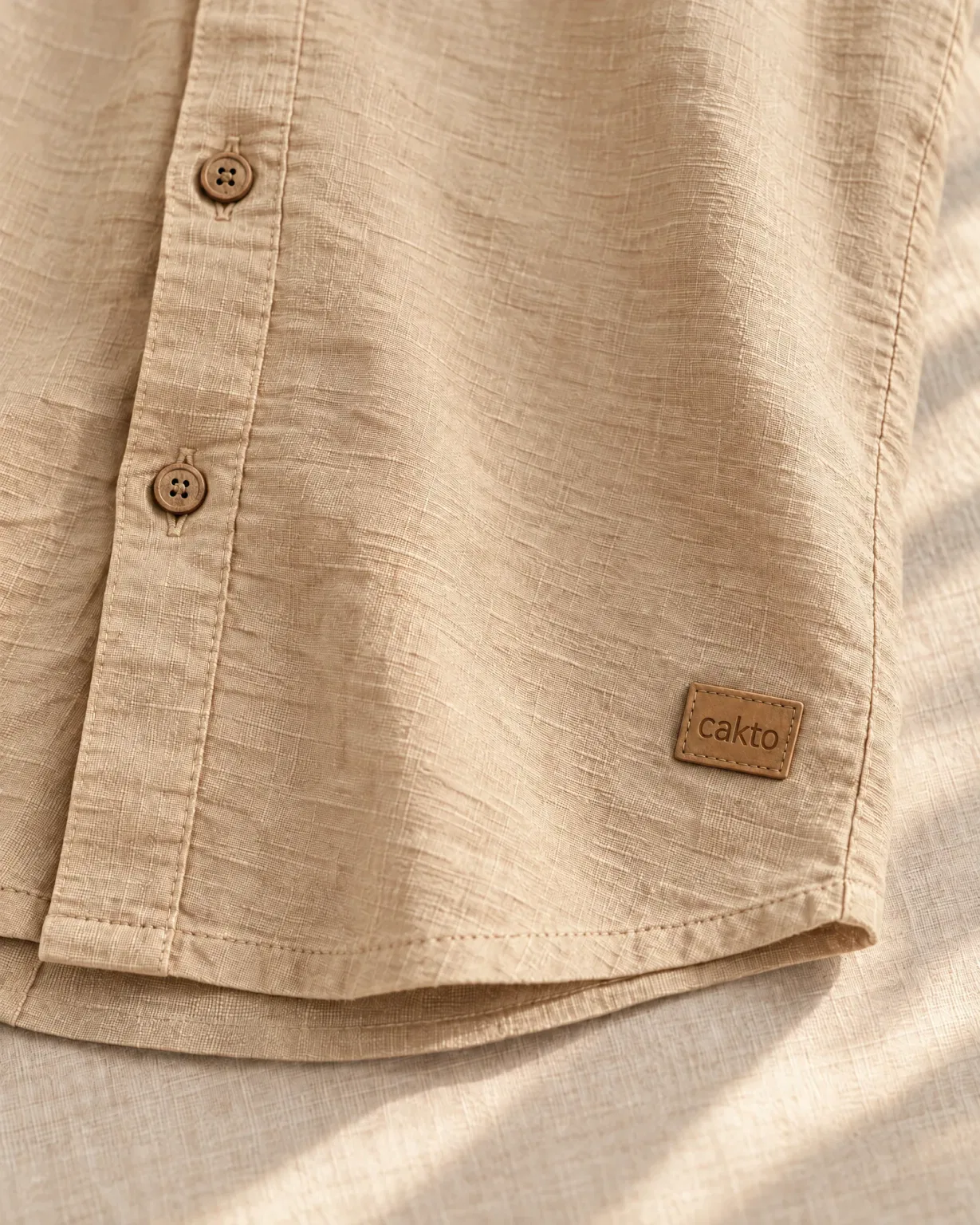 Detalle de la textura, los botones y el parche de cuero Cakto de la camisa texturizada beige