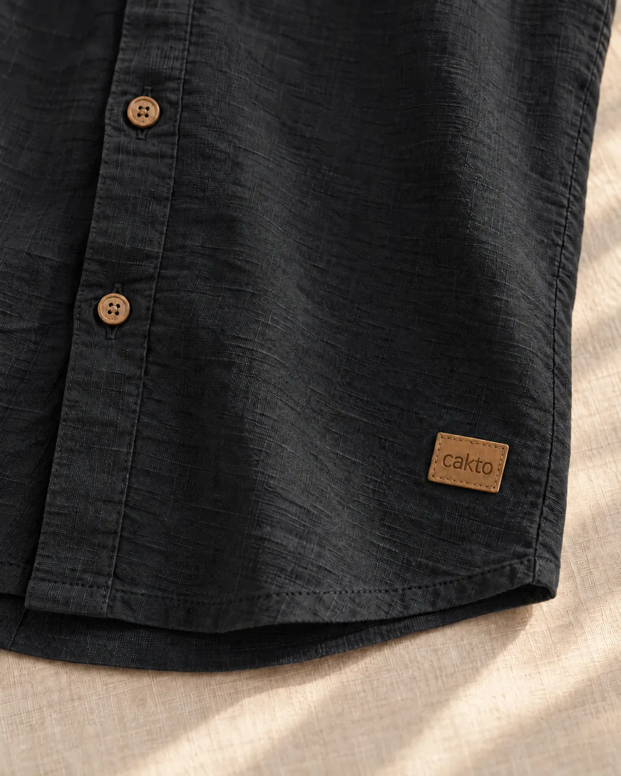 Detalle de la textura, los botones y el parche de cuero Cakto de la camisa texturizada negra