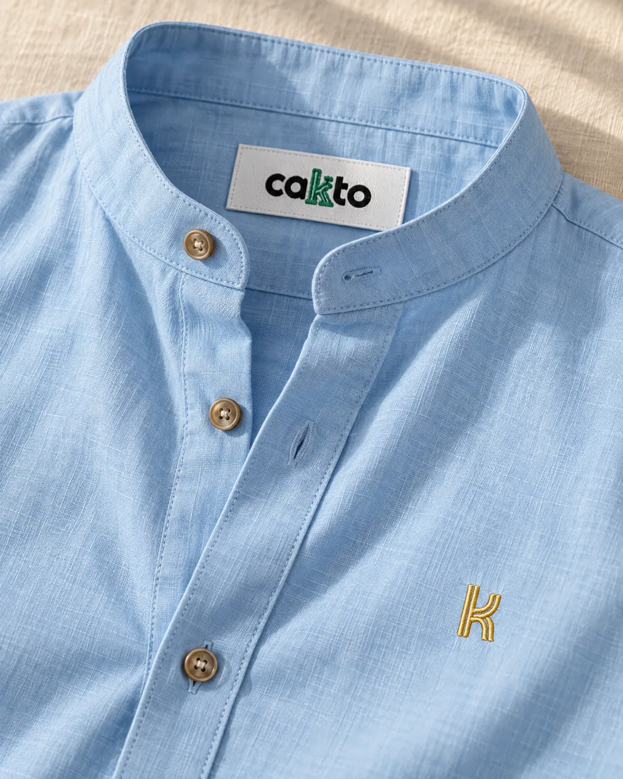 Detalle del cuello, la tela y la etiqueta Cakto de la camisa cuello neru azul