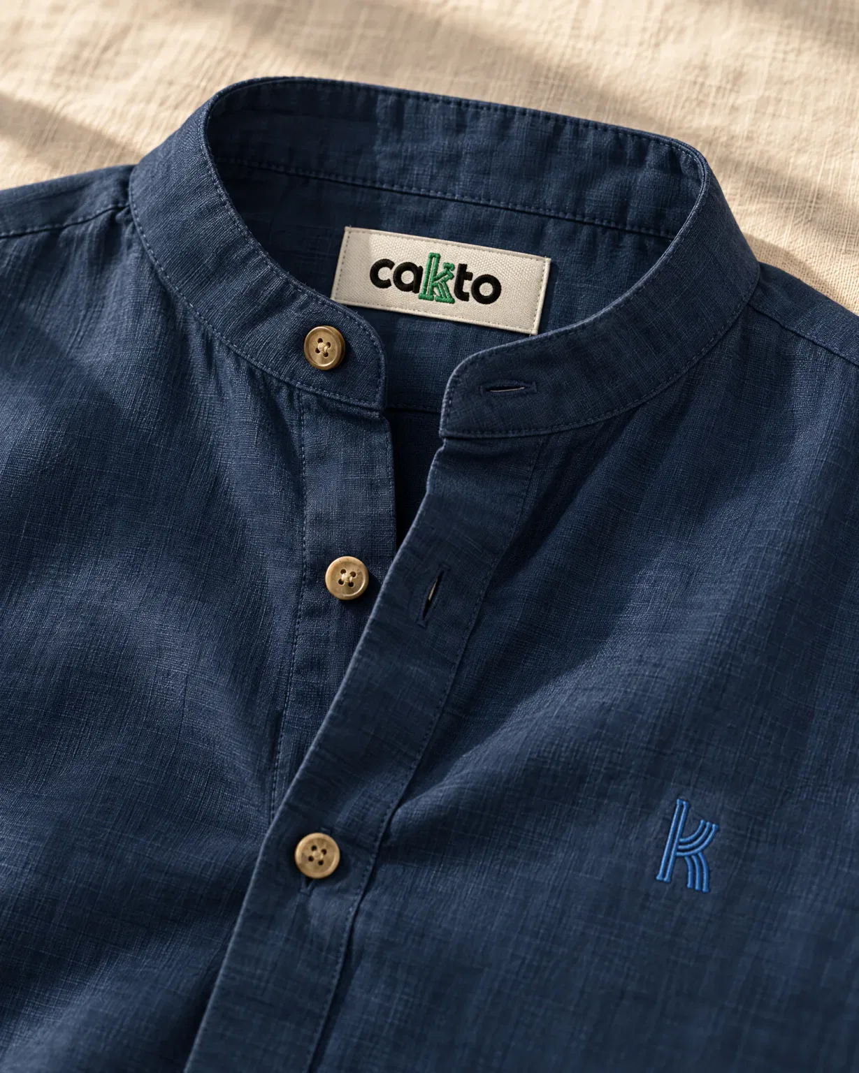 Detalle del cuello, la tela y la etiqueta Cakto de la camisa cuello neru azul oscuro