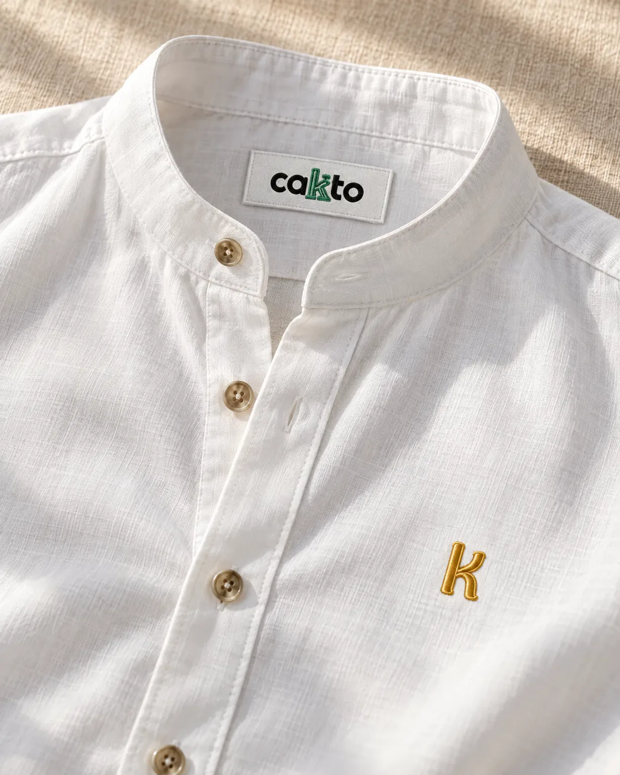 Detalle del cuello, la tela y la etiqueta Cakto de la camisa cuello neru blanca