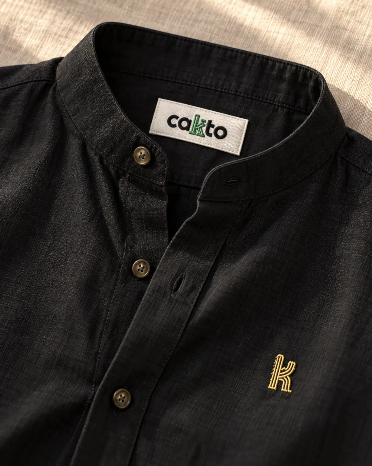 Detalle del cuello, la tela y la etiqueta Cakto de la camisa cuello neru negra