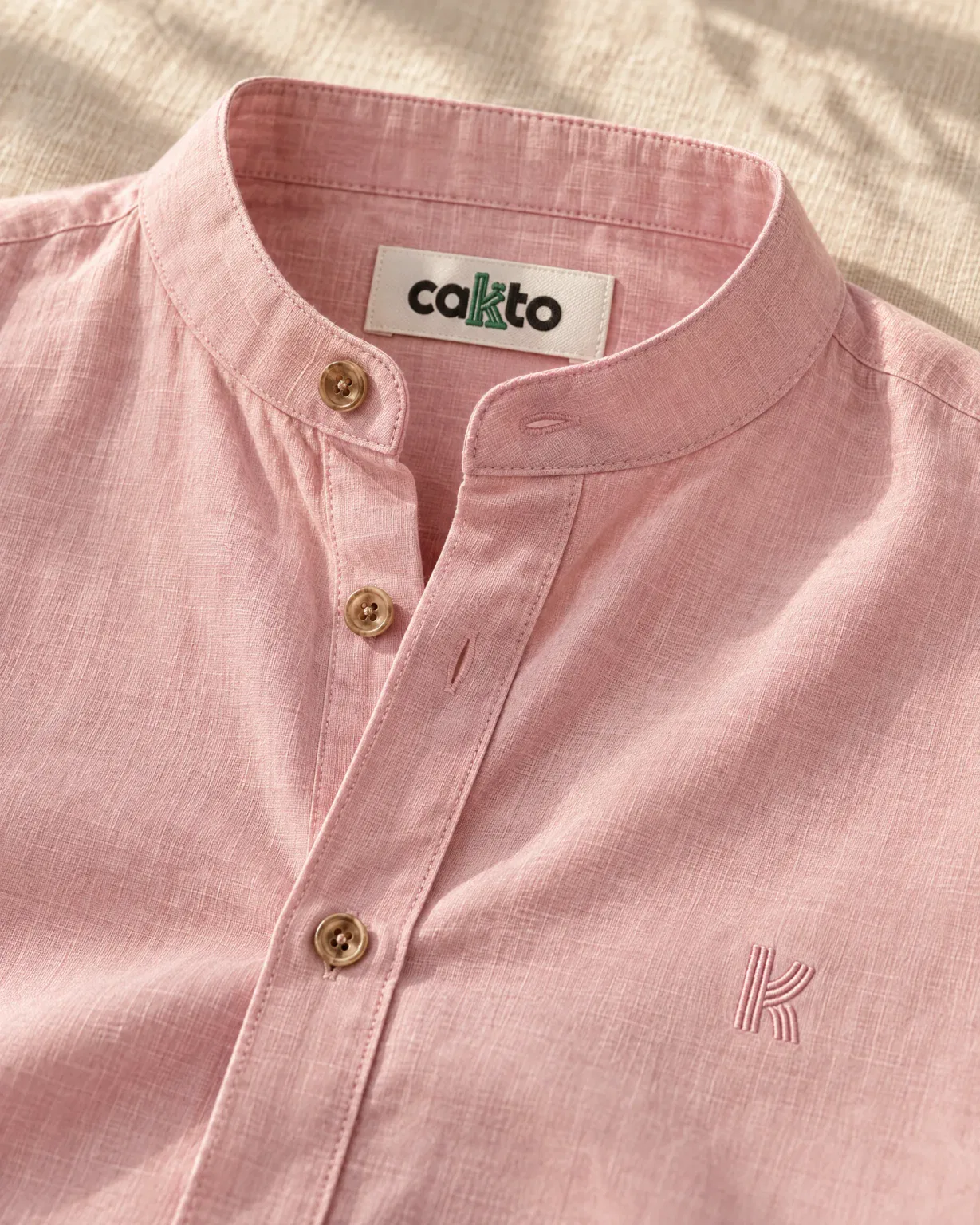 Detalle del cuello, la tela y la etiqueta Cakto de la camisa cuello neru rosa