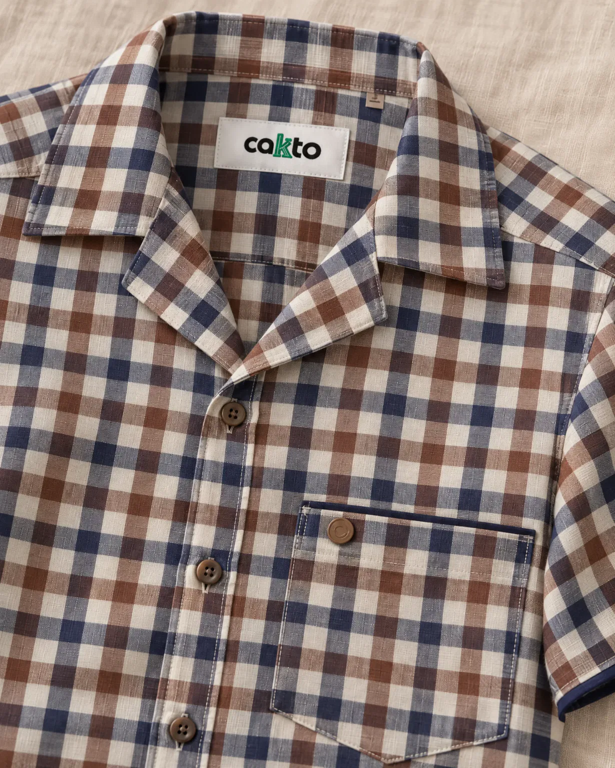 Detalle de los cuadros, el bolsillo y la etiqueta Cakto de la camisa leñadora café