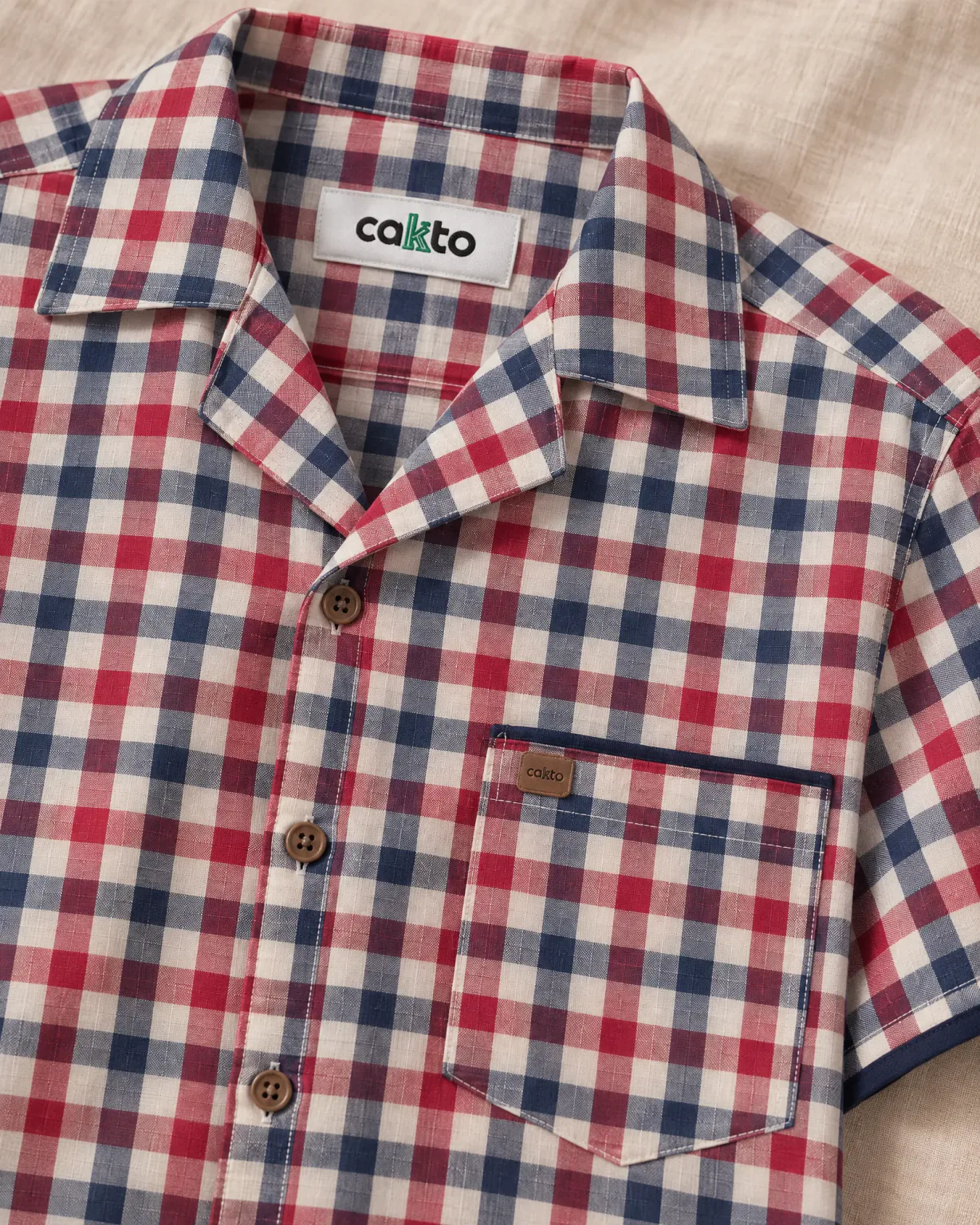 Detalle de los cuadros, el bolsillo y la etiqueta Cakto de la camisa leñadora roja