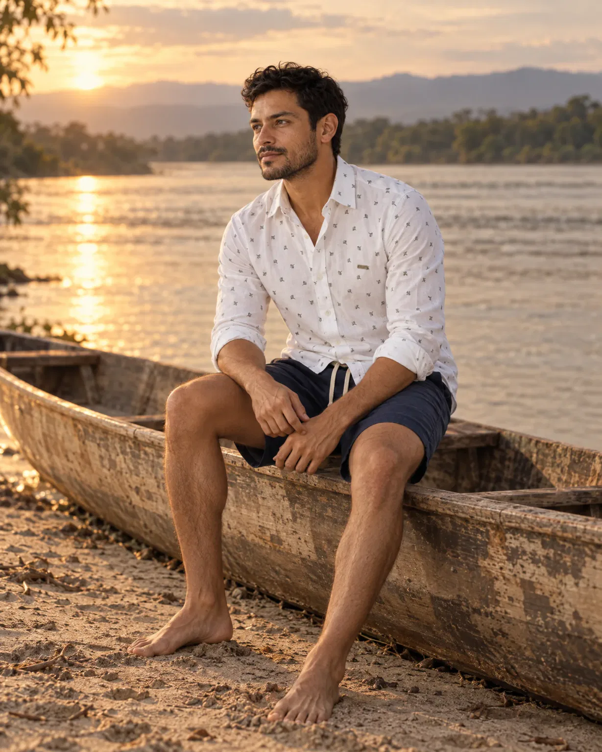 Hombre con camisa trigo blanca con bermuda de lino azul oscuro en una canoa a orillas del río Magdalena