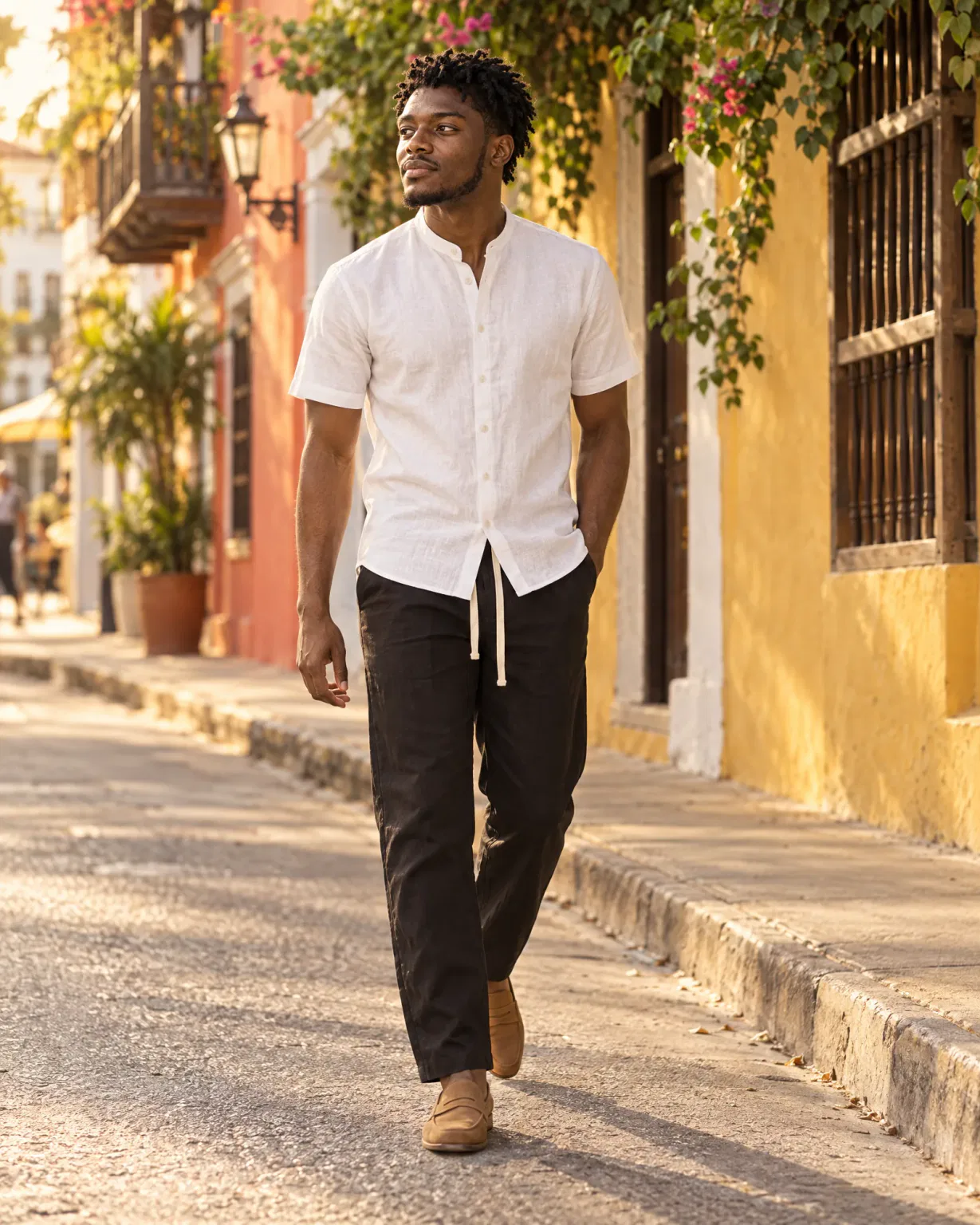 Hombre con pantalón de lino negro con camisa cuello neru blanca en una calle de Getsemaní, Cartagena