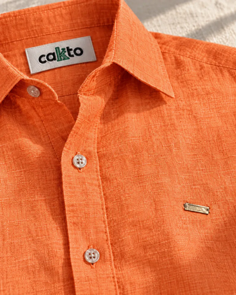 Detalle de la tela, la plaquita metálica y la etiqueta Cakto de la camisa 100% lino mandarina