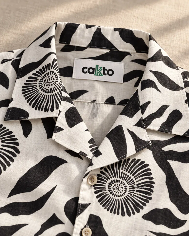 Detalle del estampado, el cuello y la etiqueta Cakto de la camisa caracol negra